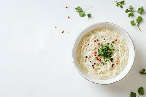 Overhead shot shows steaming noodle soup with red pepper and parsley on a table photo