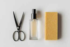 Scissors, moisturizer in a clear bottle, and cleaning sponge are positioned on white surface photo