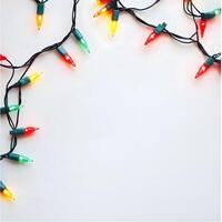 Colorful glowing festive string lights create a bright and cheerful border on a white background photo