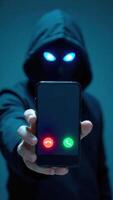 A person in a hoodie holding up a cell phone with two glowing eyes photo