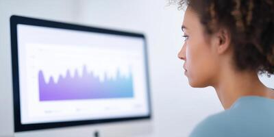 A woman is looking at a graph on a computer screen photo