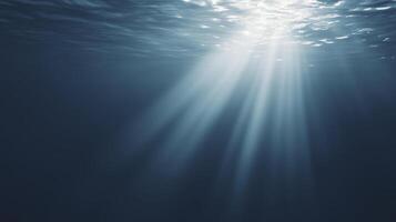 Underwater scene showcasing sunlight rays penetrating the surface, creating a serene atmosphere with shimmering reflections and deep blue hues, evoking tranquility and natural beauty photo