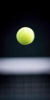Bright yellow tennis ball is captured mid-air against a blurred background, showcasing its texture and motion, symbolizing the excitement of the game and athleticism in sports photo