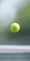 Bright green tennis ball is suspended in mid-air against a blurred background, showcasing its vibrant color and texture, representing the excitement of the sport and dynamic movement photo