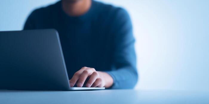 Person using laptop with hands on keyboard in a modern workspace with soft lighting and minimalistic design technology concept photo