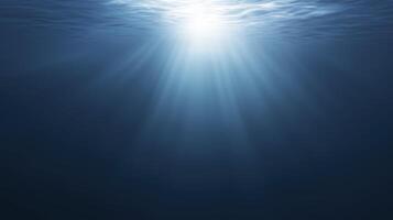 Underwater scene showcasing sunlight penetrating the surface, creating a serene atmosphere with gentle waves and deep blue hues, evoking tranquility and calmness in aquatic environments photo