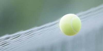 Bright yellow tennis ball is suspended in mid-air above a net, captured in motion, showcasing the dynamic energy of the sport and the excitement of a competitive game photo