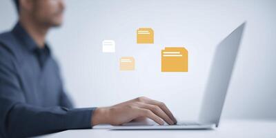 Professional man working on laptop with digital file icons floating above, showcasing modern technology and efficient data management in a contemporary workspace photo