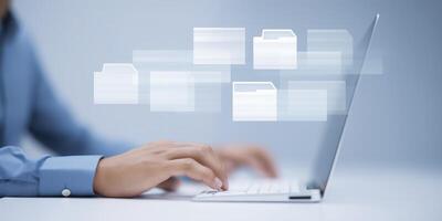 Person using laptop with floating digital file icons representing data management and organization in a modern workspace with copy space for text photo