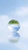 Transparent glass sphere reflecting blue sky and green trees, creating a serene and tranquil atmosphere with a sense of calm and clarity photo