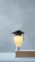 Light bulb wearing graduation cap resting on a stack of books symbolizes education and the pursuit of knowledge in a creative and inspiring manner photo