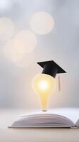 Light bulb wearing graduation cap hovering above an open book with soft bokeh background representing education and inspiration for learning and creativity photo