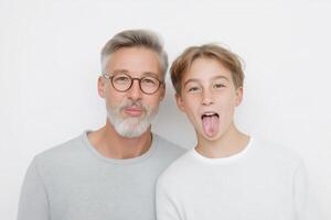 Elderly man with glasses and young boy making funny faces together, showcasing joyful family moments and playful interactions in a bright atmosphere photo