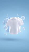 Three floating shirts in various colors, white and light blue, displayed against a soft blue background with bubbles, showcasing a clean and fresh laundry concept photo