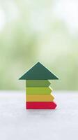 Colorful wooden blocks arranged in a house shape symbolize growth and progress, featuring green, yellow, red, and orange colors against a soft blurred background photo