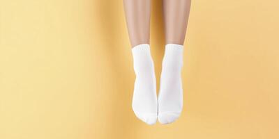 White socks on feet are suspended against a bright yellow background, showcasing a minimalist design that emphasizes comfort and casual style in everyday wear photo