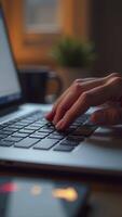 Programmer writing code on laptop keyboard in home office at night photo