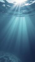 Sunbeams filtering through ocean surface to dark seabed photo