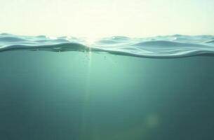 Sunlight entering deep clear ocean water with bubbles rising to surface photo