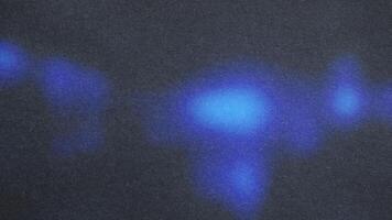 Blue light painting on dark textured background creating abstract shapes photo
