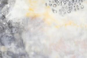 Abstract textured surface with organic patterns in gray and yellow hues photo