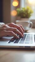 Woman working remotely is typing on laptop keyboard in cozy home office photo