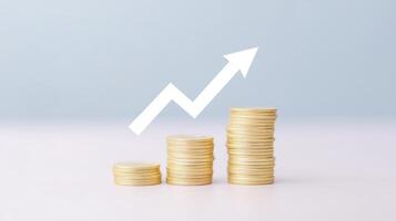 Stacks of golden coins arranged in ascending order with a white upward arrow symbolizing financial growth and success against a soft blue background, representing investment and prosperity photo