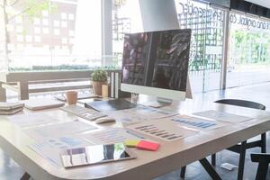 A desk with a computer, papers and a phone photo