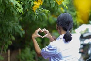 A woman making a heart shape with her hands photo