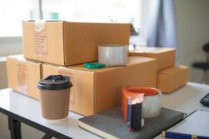 A desk with a laptop, coffee cup, and a stack of boxes photo