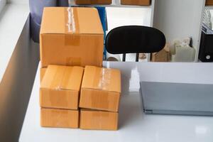 A stack of boxes on a desk next to a laptop photo