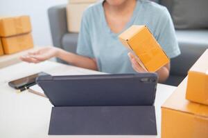 A woman is holding a box with a tablet computer photo