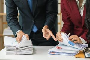 Two business people in suits and ties looking at paperwork photo