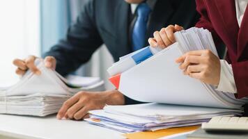 Two business people are working on paperwork at a desk photo