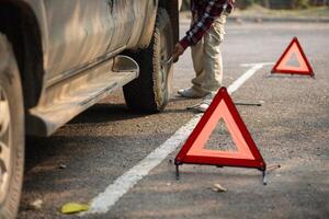 A man is fixing a tire on a car photo