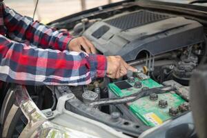 A man is working on the engine of a car photo