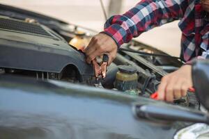 A man is working on a car engine photo
