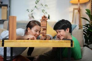Mother and Son Playing Block Game at Home, Happy Family Bonding with Fun Indoor Game, Parent and Child Enjoying Quality Time Together photo