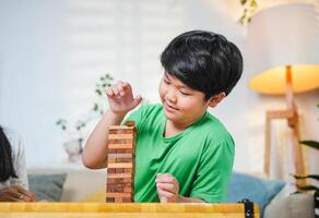 Close up of Boy Playing Block Tower Game Indoors photo