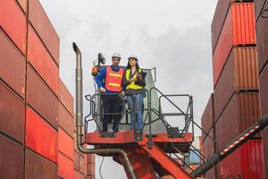 Team of Workers Standing on Crane in Container Yard, Logistics Engineers Inspecting Shipping Containers at Cargo Port photo