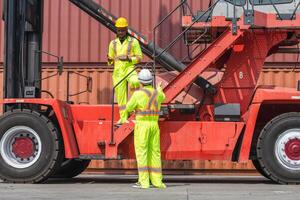 Dock Workers Discussing Operations Near Cargo Handler, Industrial Workers in Safety Gear at Container Terminal, Heavy Equipment Operators Communicating at Shipping Port photo