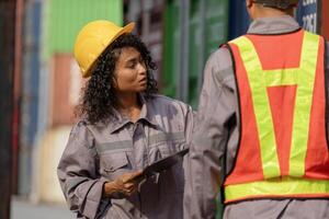 Female Engineer Inspecting Cargo Containers with Tablet, Logistics Professional Inspecting Containers Box at Shipping Container Yard photo