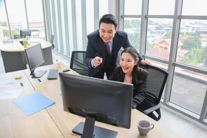 Business colleagues discussing data at desk, Asian professional business meeting in office, Supervisor training and suggesting about work to colleagues photo