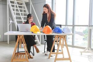 Young women team discussing ideas and planning strategy in office, Female engineers discussing plans in modern office, Engineer and architecture meeting and brainstorming together at project site photo