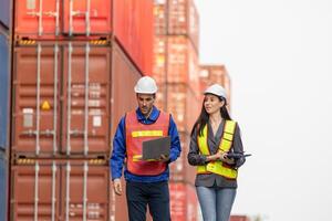 Foreman dock workers checking loading containers box at shipping yard, Logistics workers at shipping port with containers, Industrial engineers managing cargo operations photo