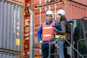 Engineers and Foreman Workers Team on Loaded Container Handler Control Loading Containers Box at at Shipping Yard photo