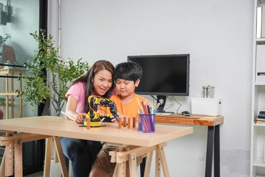 padre y niño explorar tecnología con robótico equipo, madre y hijo aprendizaje robótica juntos, joven chico comprometido en vástago educación con robot brazo foto