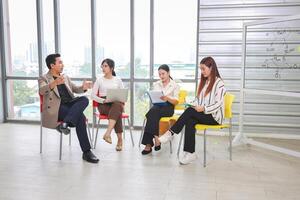 Group of Colleagues Engaged in Brainstorming Session, Asian Professionals Collaborating Meeting on Project, Business Team Discussion in Modern Office photo