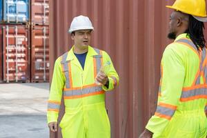 Construction Workers in Reflective Gear Discussing Project, Two Industrial Workers on Site with Shipping Containers photo