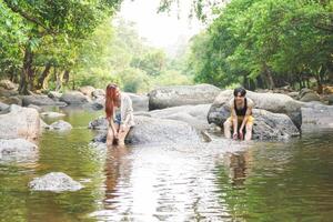 Young Couple Relaxing in a Serene Jungle River, Friends Enjoying a Refreshing Swim in Nature photo